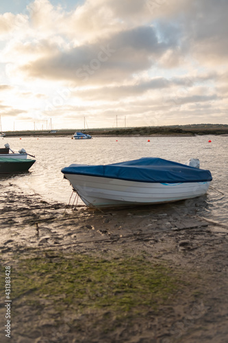 Small and privately owned leisure boat on the mud at low tide in Wells-Next-The-Sea estuary on the North Norfolk coast