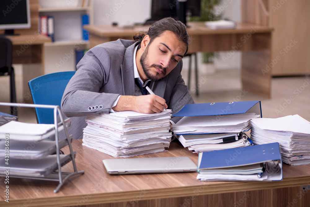 Young businessman employee unhappy with excessive work in the of Young businessman employee unhappy with excessive work in the of
