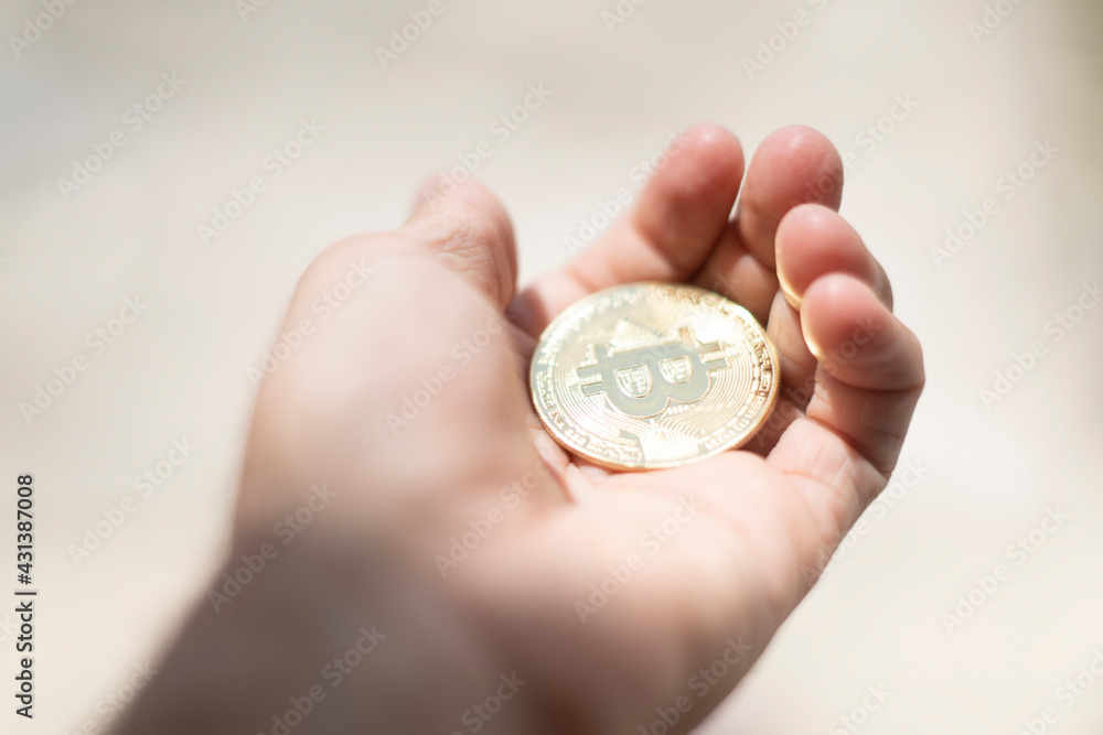 Bitcoin. Hand holding gold coin with BTC symbol. Person investing in virtual assets like cryptocurrency concept background Bitcoin. Hand holding gold coin with BTC symbol. Person investing in virtual assets like cryptocurrency concept background