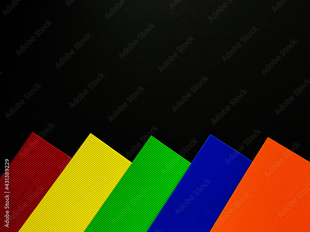 On a black background, colorful sheets of cardboard with a texture On a black background, colorful sheets of cardboard with a texture