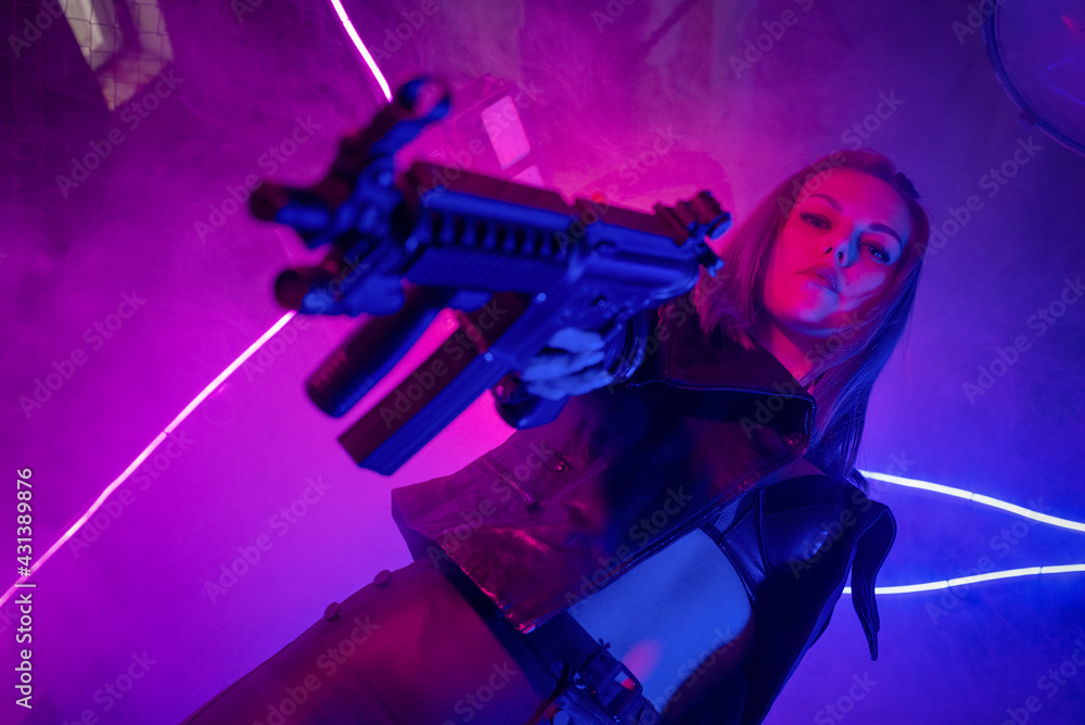 Cyberpunk girl with a rifle in the neon lights. Stock Photo | Adobe Stock