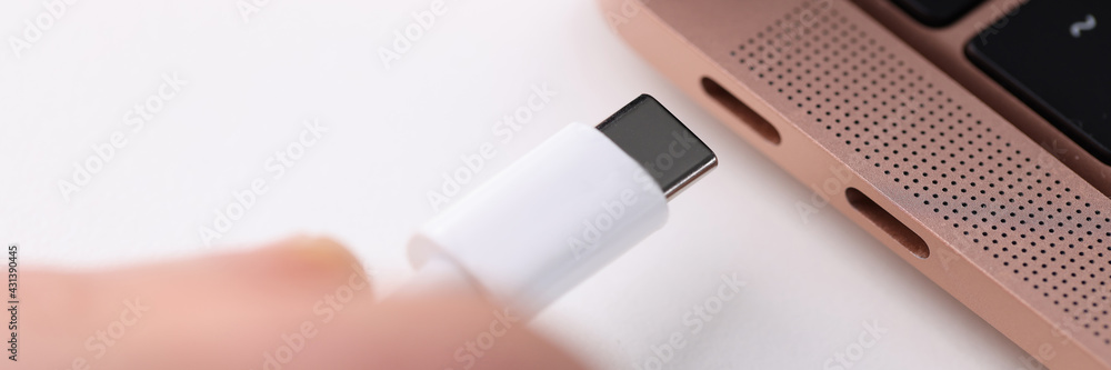 White charger is inserted into a socket in laptop White charger is inserted into a socket in laptop
