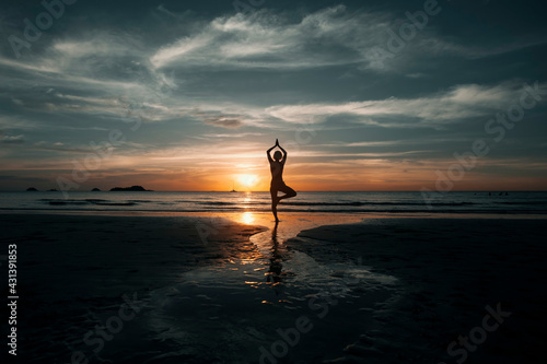 Yoga woman doing meditation on the ocean beach.