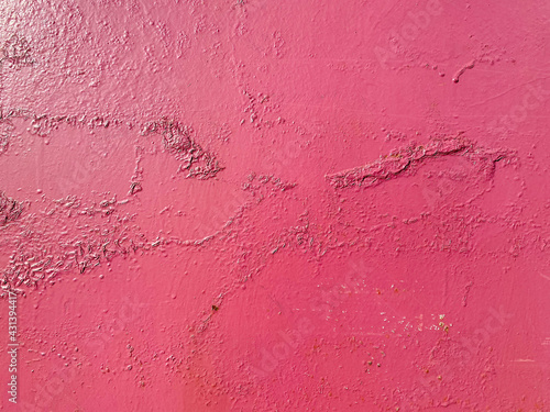 Red pinkish texture of a metallic iron old wall painted with cracks and abrasions. The background. Texture