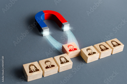 Fotografie The magnet pulls a red person figure out of the row