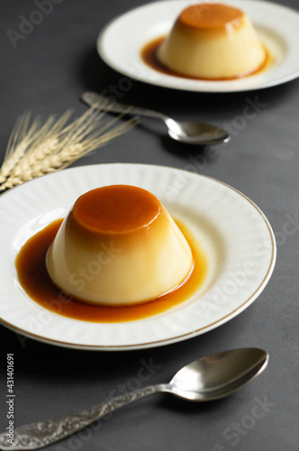 Cream caramel pudding with caramel sauce in plate on white rustic table
