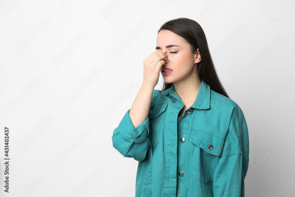 Young woman suffering from runny nose on white background. Space for text Young woman suffering from runny nose on white background. Space for text
