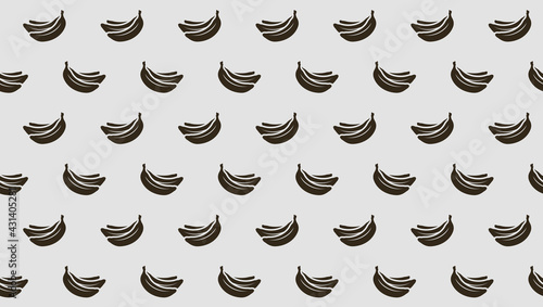 Endless seamless pattern with black ripe bananas on a gray background. Wallpaper with windy bananas.