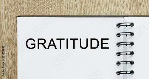 Notepad with text Gratitude on wooden deskt. Business and finance concept photo