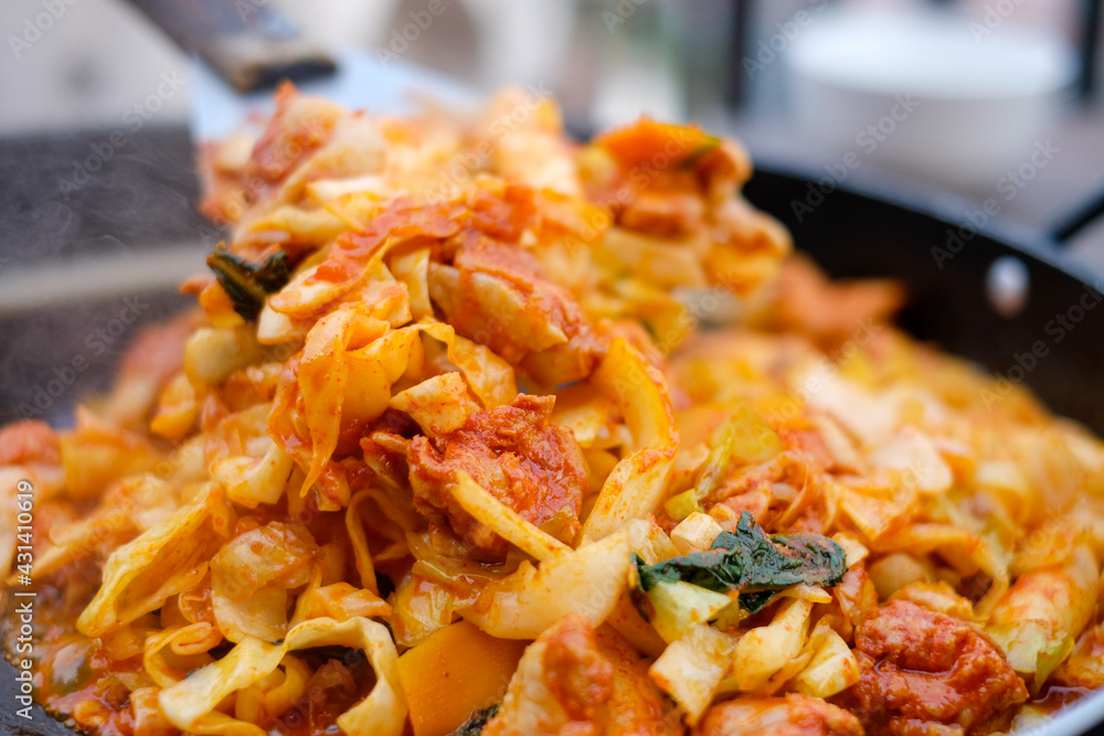 Close up fried Korean food called “Dakgalbi”with spade of frying pan,it's Korean style Chicken