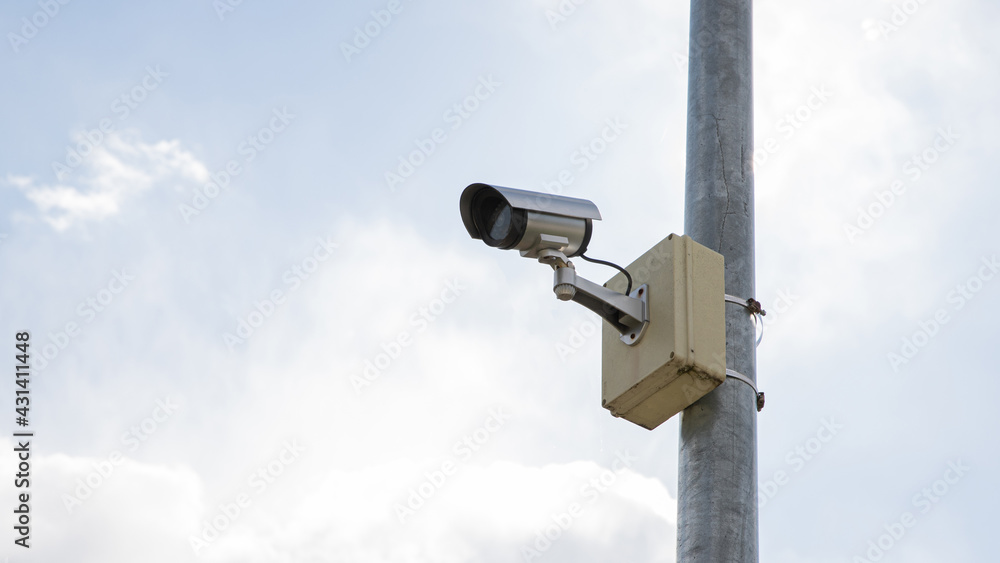 Surveillance camera mounted on a pole with sky background. Surveillance camera mounted on a pole with sky background.