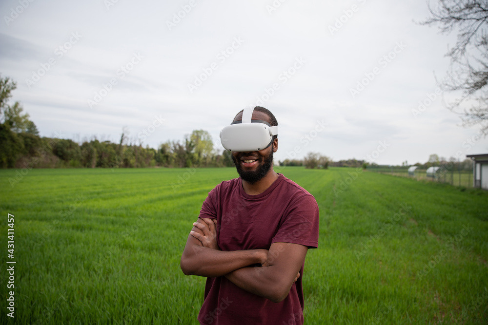 an African boy plays with his virtual reality headsets in a field. an African boy plays with his virtual reality headsets in a field.