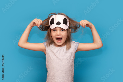 Wallpaper Mural Spoiled little girl in sleeping mask, tearing her hair isolated on blue background. Stressed kid. Screaming, be mad and naughty. Angry child want sleep. Genuine human emotions, reaction and body Torontodigital.ca