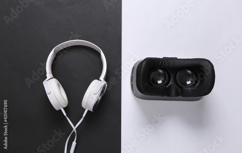 Modern gadgets. Headphones and vr helmet on white black background. Top view
