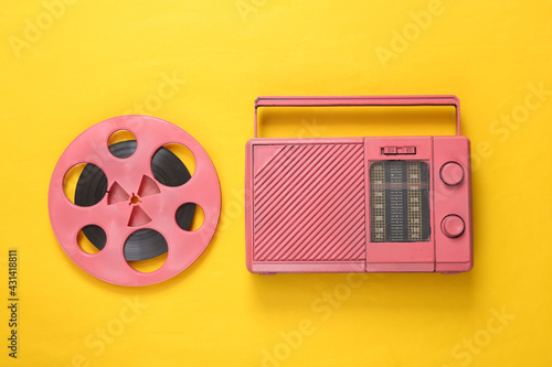 Pink Audio reel and cool radio receiver on yellow background. Musical concept. Top view. Flat lay