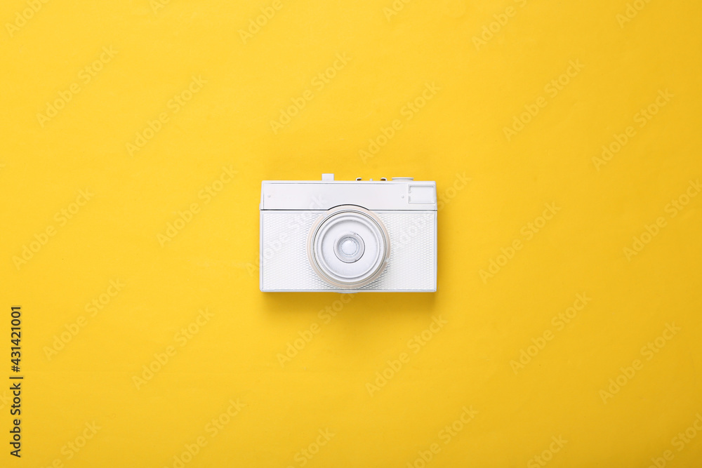 Creative layout. White retro camera on yellow background. Minimalism. Concept art. Modern still life. Flat lay. Top view. Creative layout. White retro camera on yellow background. Minimalism. Concept art. Modern still life. Flat lay. Top view.