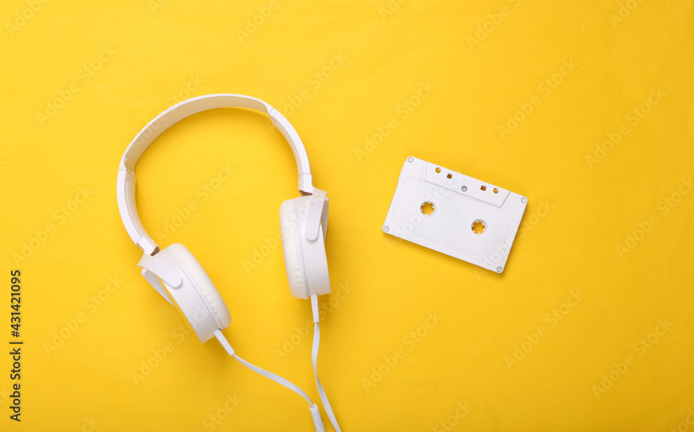 White headphones with audio cassettes on yellow background. Creative music layout. Top view. Flat lay White headphones with audio cassettes on yellow background. Creative music layout. Top view. Flat lay