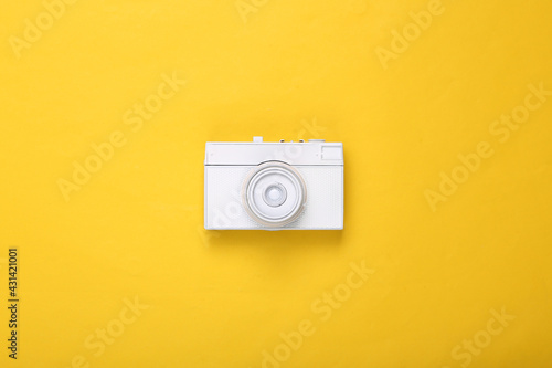 Creative layout. White retro camera on yellow background. Minimalism. Concept art. Modern still life. Flat lay. Top view.