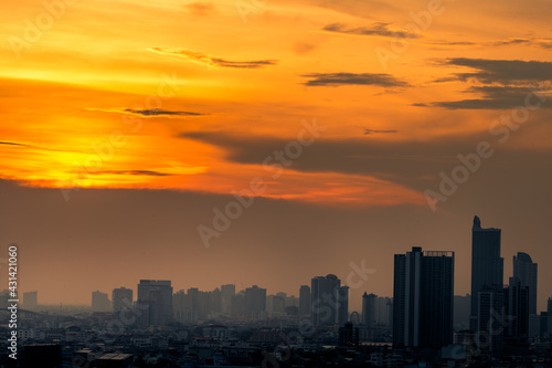 The blurred abstract background of the morning sun exposure to the tiny dust particles that surround the tall buildings in the capital, the long-term health issue of pollution. © bangprik