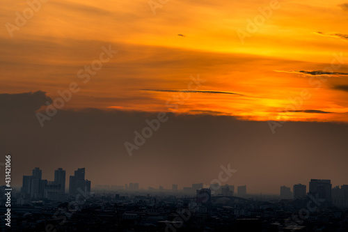 The blurred abstract background of the morning sun exposure to the tiny dust particles that surround the tall buildings in the capital, the long-term health issue of pollution. © bangprik