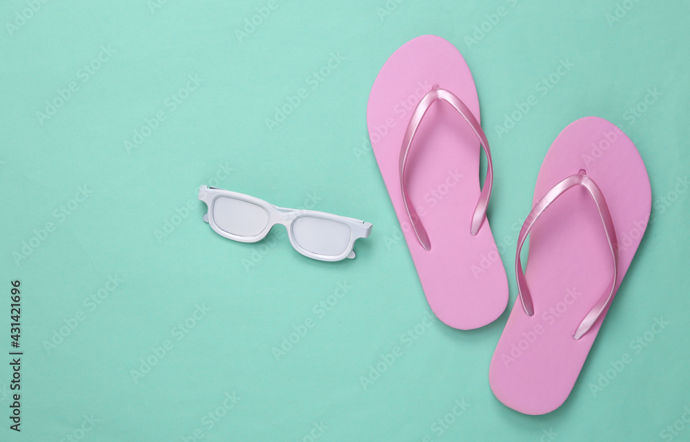 Minimalism travel layout. Flip-flops and white sunglasses on mint blue background. Top view. Flat lay