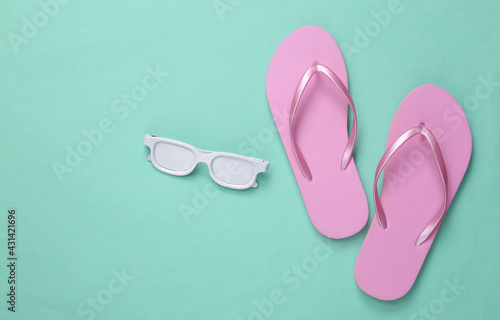 Minimalism travel layout. Flip-flops and white sunglasses on mint blue background. Top view. Flat lay