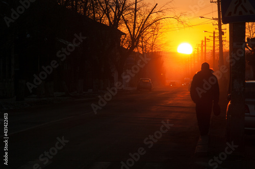 silhouette of a person walking in the city at sunset