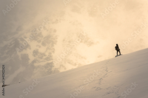 person walking in the snow in mountains