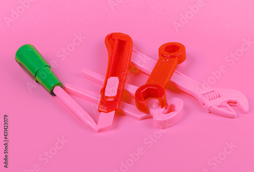 Set of children's toy work tools on pink background
