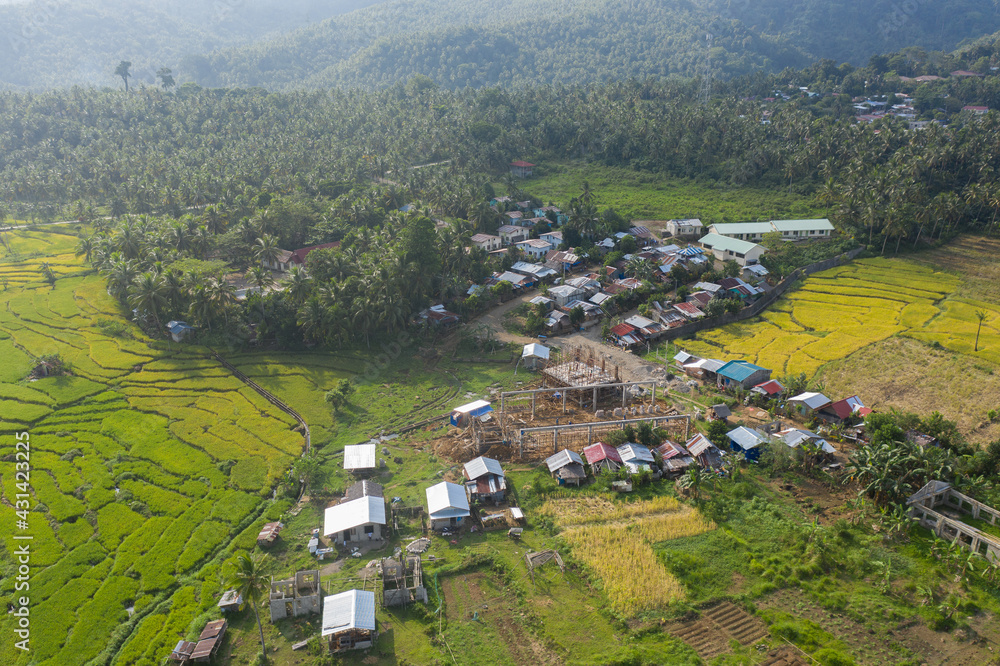 Aerial Drone Shot View of Houses and Buildings on a Mountain Village in a Tropical Island in the Philippines. During Hot Summer Holiday Vacation with Green Sceneries