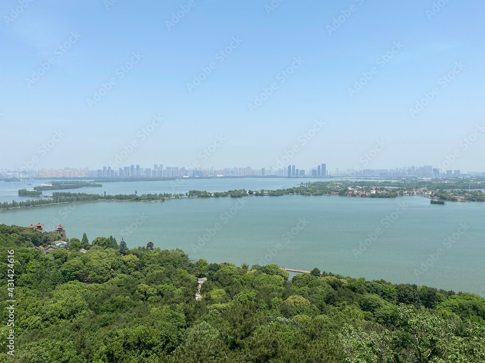 Wuhan East Lake scenic spot.  Green Moshan Hill. East Lake and Wuhan skyline.