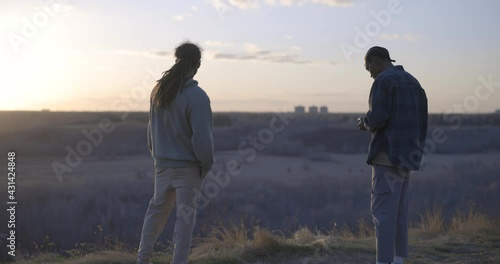 two friends standing in nature smoking