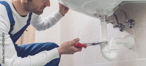 Cuadro en lienzo Plumber fixing a sink at home