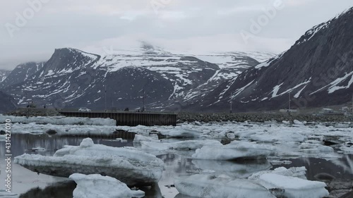 Camera tracking shot pans left in the distant ATV in Pangnirtung Nunavut. photo