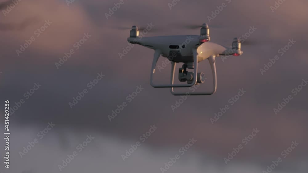 Quadcopter hovering then descending at sunset, CLOSE Quadcopter hovering then descending at sunset, CLOSE