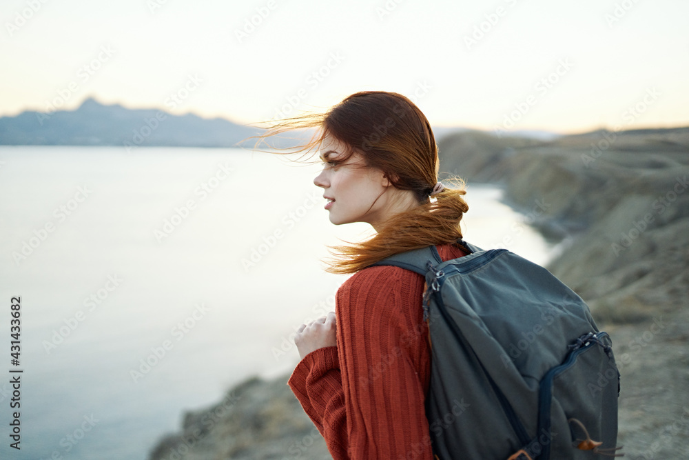 woman travels in the mountains in nature near the sea side view woman travels in the mountains in nature near the sea side view