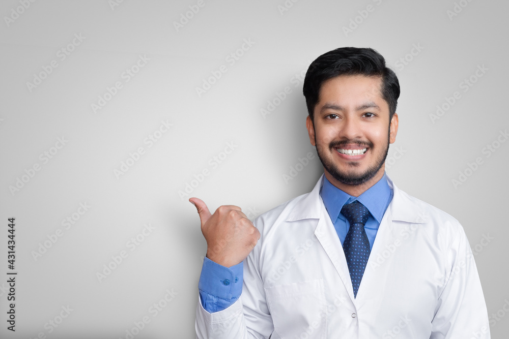 Doctor wearing uniform smiling while presenting and pointing isolated with copy space Doctor wearing uniform smiling while presenting and pointing isolated with copy space