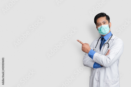 Doctor holding stethoscope in neck while smiling and presenting  isolated on white background with copy space