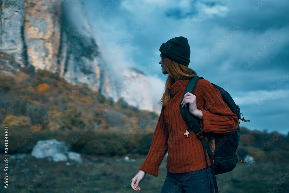 Traveler in a sweater with a backpack on her back tourism clouds sky landscape Traveler in a sweater with a backpack on her back tourism clouds sky landscape