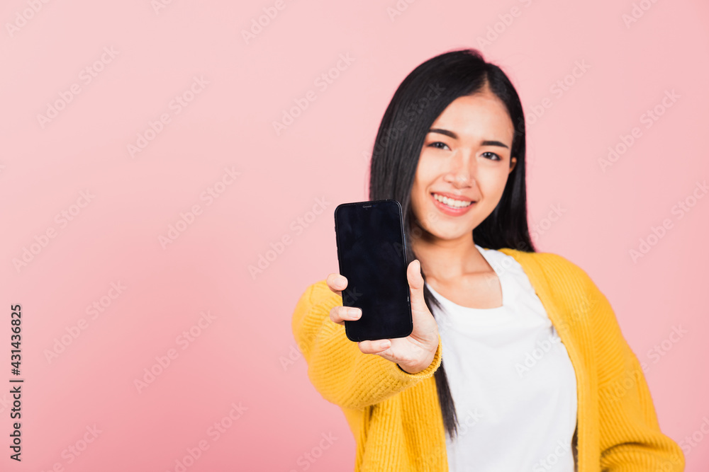 Happy Asian portrait beautiful cute young woman teen smiling excited holding blank screen mobile phone studio shot isolated on pink background, Thai female show smartphone empty screen space Happy Asian portrait beautiful cute young woman teen smiling excited holding blank screen mobile phone studio shot isolated on pink background, Thai female show smartphone empty screen space