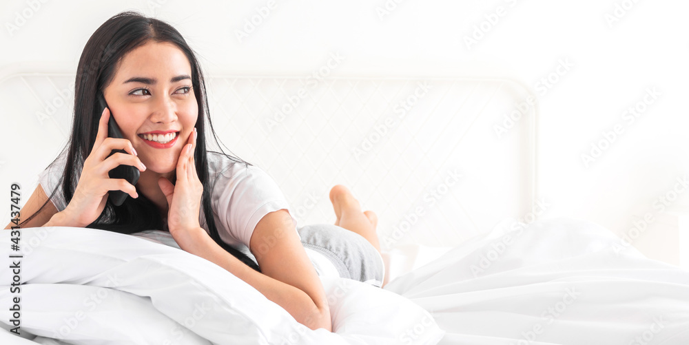 Portrait of smiling happy beautiful asian woman relaxing using digital technology smartphone.Young asian girl call and talk with friend at home Portrait of smiling happy beautiful asian woman relaxing using digital technology smartphone.Young asian girl call and talk with friend at home