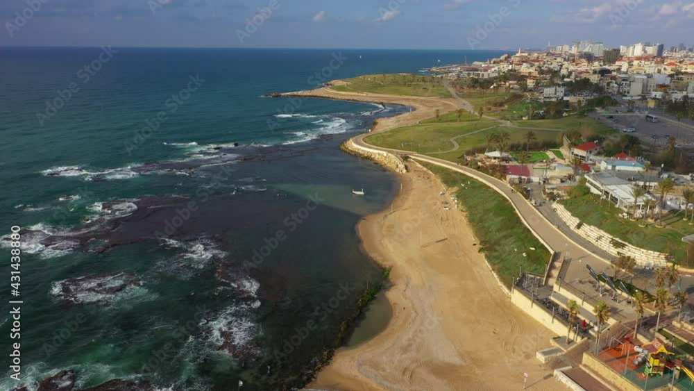 Aerial Shot Of Waves Splashing On Shore At Beach By Houses, Drone Flying Forward Over Coastal City Against Sky - Jaffa, Israel Aerial Shot Of Waves Splashing On Shore At Beach By Houses, Drone Flying Forward Over Coastal City Against Sky - Jaffa, Israel