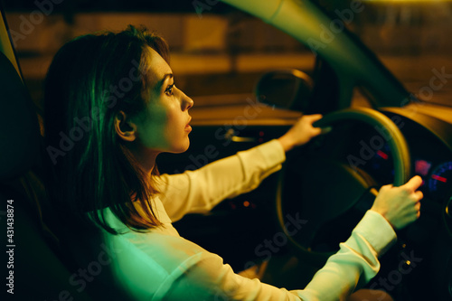 Young woman going on a road trip by car at night.