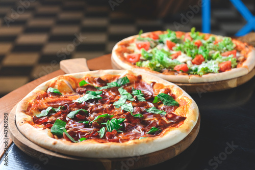 Fresh tasty pizza served on a wooden table in restaurant or diner over blurred background.