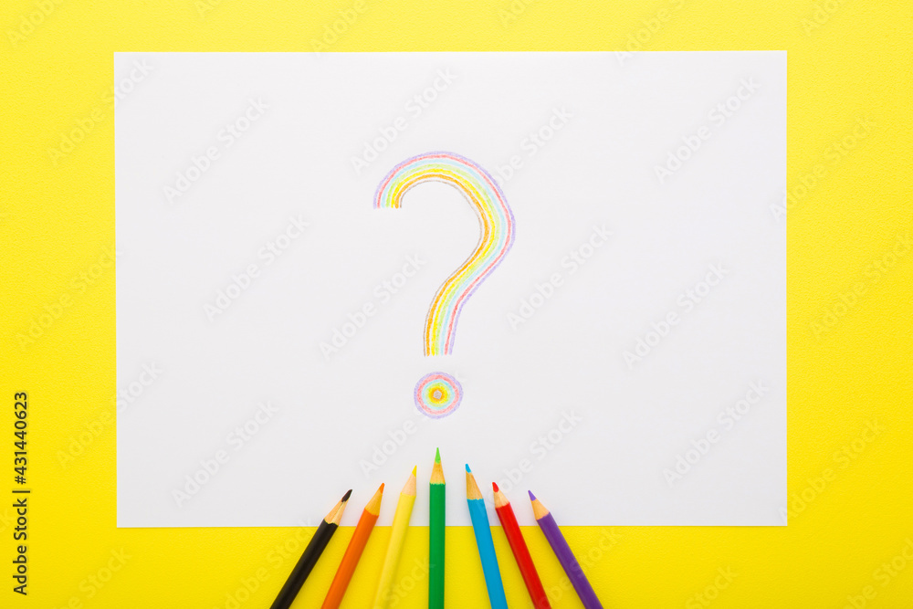 One colorful question sign on white paper with pencils on bright yellow table background. Closeup. Top down view. One colorful question sign on white paper with pencils on bright yellow table background. Closeup. Top down view.