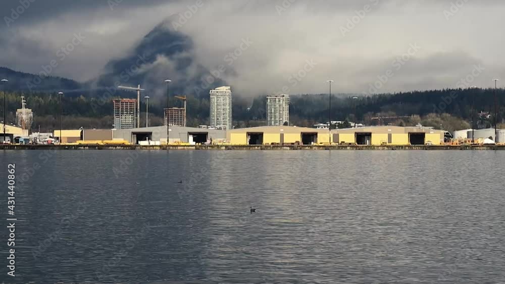 Ship terminal and loading docks with mountains covered with clouds behind Ship terminal and loading docks with mountains covered with clouds behind