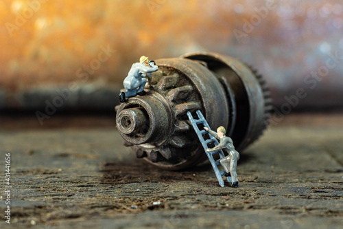 Miniature people check and repair Old gear is damaged