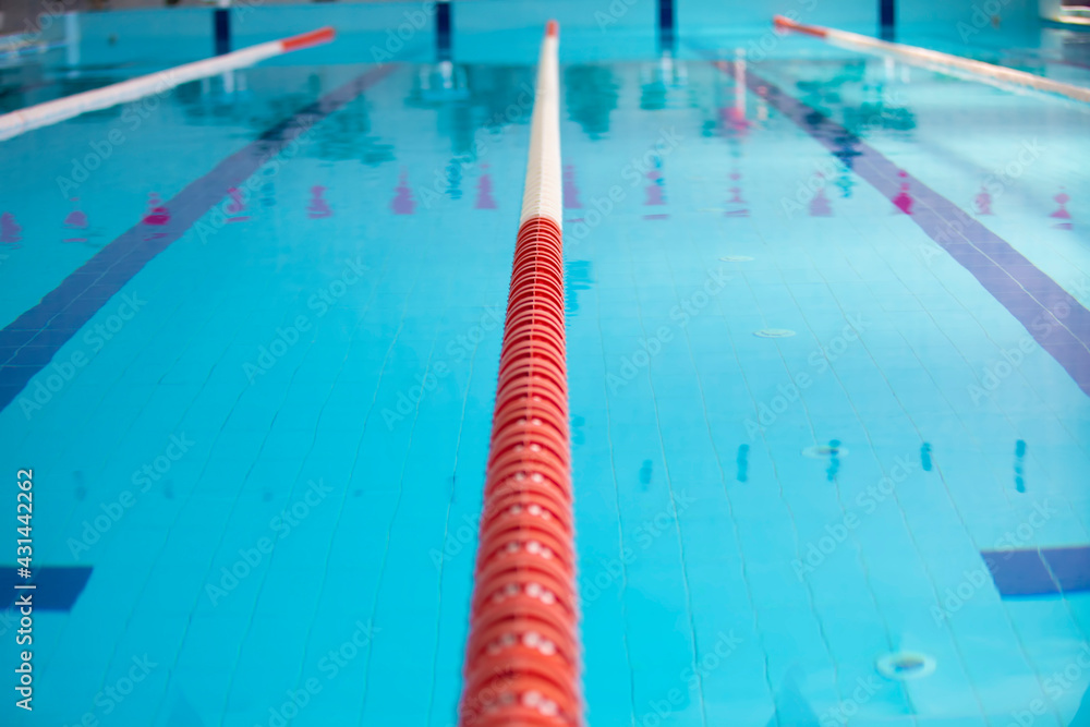 An empty sports pool with a red dividing path. Blue water in the swimming pool.