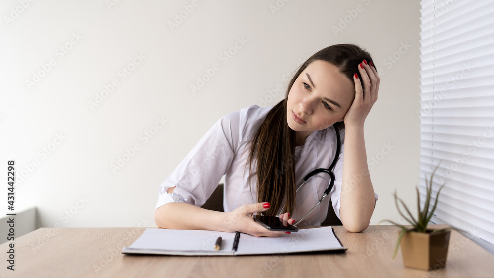 Burnout at work, young caucasian woman doctor sitting at a table in a hospital. Headache, failure, frustration. Burnout at work, young caucasian woman doctor sitting at a table in a hospital. Headache, failure, frustration.