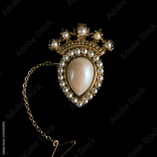 vintage gold brooch in the shape of a crown with pearls. antique crown brooch in flowers
